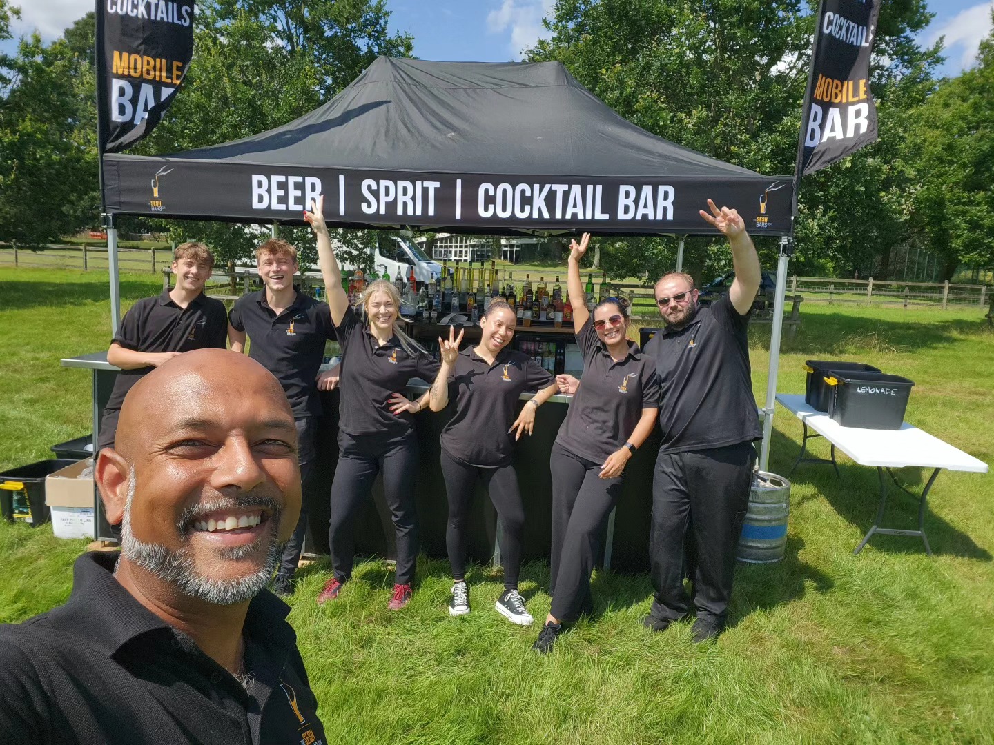 The Sesh Bars bartender team at an outdoor festival mobile bar setup
