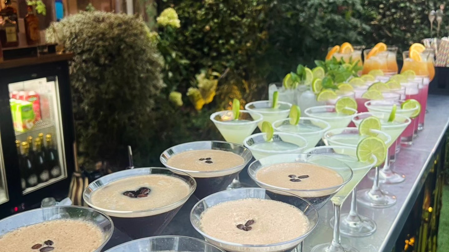 Espresso martinis and margaritas lined up on a mobile cocktail bar at a London event