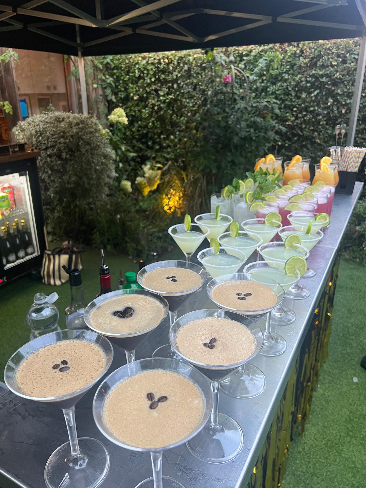 Full cocktail spread at a garden event, espresso martinis, margaritas, and more