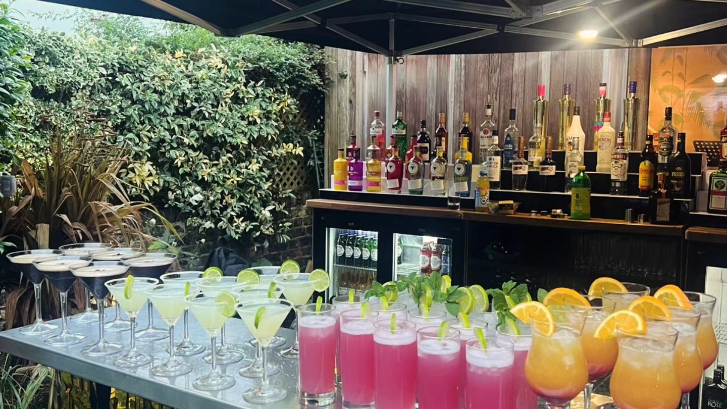 Pop-up mobile bar fully stocked with spirits, cocktails, and beer fridges at an outdoor event